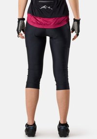 Schwarze Radsport-Hosen mit einer Länge bis zur Wade, glatter Textur und nahtlosem Design; Rückentasche auf einem enganliegenden Oberteil, ergänzt durch fingerlose Handschuhe.
