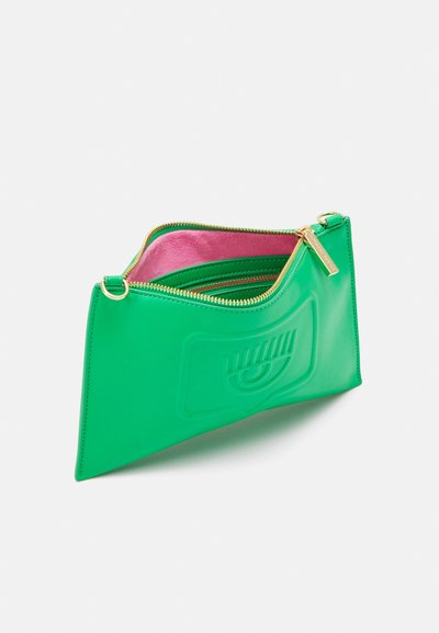 Green, shiny leather clutch bag with a zip closure, pink interior, and embossed design on the front. Gold hardware accents.
