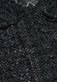 Zwart gebreid stof met een textuurpatroon, met open weefsel en metallic draad accenten voor een glinsterend effect.