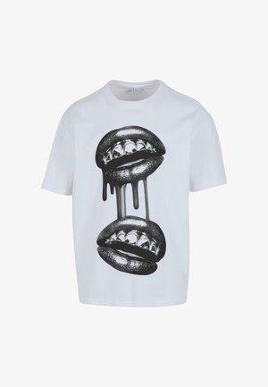 Hvit bomulls t-skjorte med et grafisk design av to lepper med sølvtenner og svarte dråpeakcenter i midten.