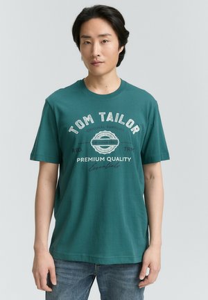 Teal kortærmet t-shirt fra Tom Tailor, med et grafisk design med tekst i hvid og mørkeblå. Enkel rund hals og blød stoftekstur.