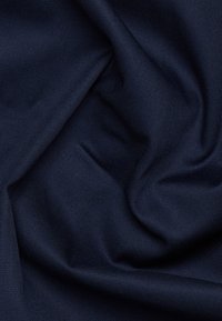 Dunkelblaues gewebtes Stoff mit glatter Textur, das weiche Drapierung und subtilen Glanz zeigt. Keine sichtbaren Muster oder Hardwaredetails.