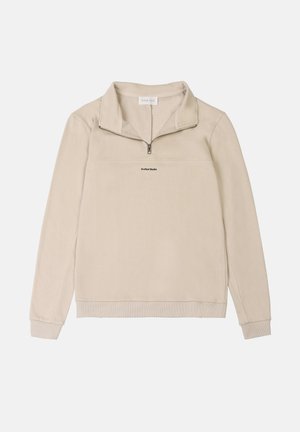 Suéter de media cremallera beige, hecho de una tela suave, con un dobladillo y puños acanalados, y un pequeño logo impreso sobre el pecho.