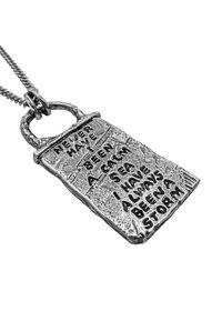 Söljtonad hängsmycke med texturerad yta och ingraverad text: "JAG HAR ALDRIG VARIT EN LUGN HAV, JAG HAR ALLTID VARIT EN STORM."