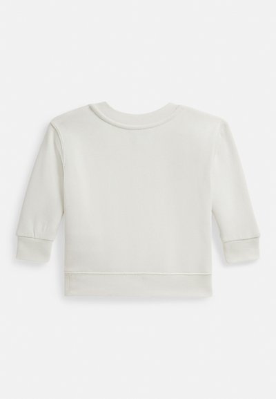 Svijetlo bež dugi rukav majice s okruglim izrezom, rebrastim manšetama i glatkom teksturom. Ima ušivene rubove na dnu.