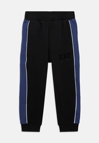 Čierne tepláky so modrými bočnými panelmi a bielym lemovaním, elastický pás a manžety na členkoch, logo EA7 Emporio Armani na stehne.