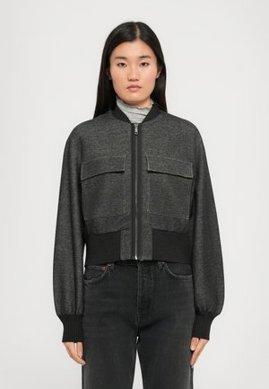 Veste bomber coupée en tissu gris foncé, avec deux poches poitrine, des poignets côtelés et une fermeture éclair à l'avant.