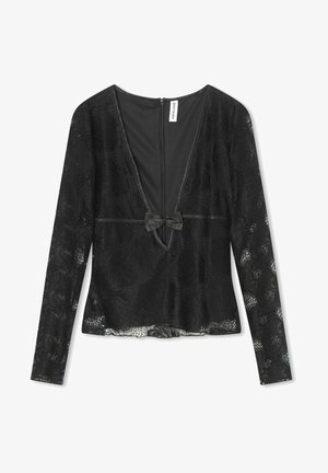 Zwarte kant top met lange mouwen, diepe V-hals en strikdetail in de taille. Kenmerkt bloemenpatronen en een ritsluiting aan de achterkant.