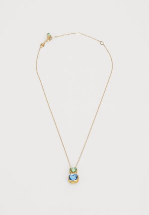 Zlatna ogrlica s dvostrukim privjeskom, s zelenim draguljem na vrhu i velikim plavim draguljem ispod, oboje smješteno u teksturiranim zlatnim okovima.