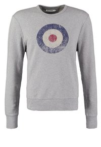 Sweat-shirt gris clair à manches longues avec un logo cible circulaire usé en rouge, blanc et bleu sur la poitrine et des poignets côtelés.