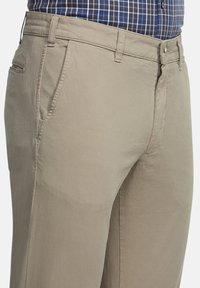 Beige katoenen broeken met een rechte pijp ontwerp, voorzien van steekzakken, een ritssluiting en gestikte naden. Gelaagde stof met een subtiele glans.