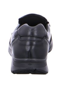 Schwarzer Lederschuh mit glatter Textur, abgerundetem Absatz und Gummisohle. Verfügt über minimale Nähte und ein praktisches Slip-On-Design. Mit dezentem Branding akzentuiert.