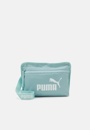 Lyseblå Puma-pung med lynlåslomme foran og justerbar rem med Puma-logo i hvid.