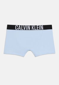 Ανοιχτό μπλε ανδρικά εσώρουχα boxer με μαύρη ζώνη μέσης που φέρει την επιγραφή "Calvin Klein" σε λευκά γράμματα, τοποθετημένα επίπεδα σε λευκό φόντο.