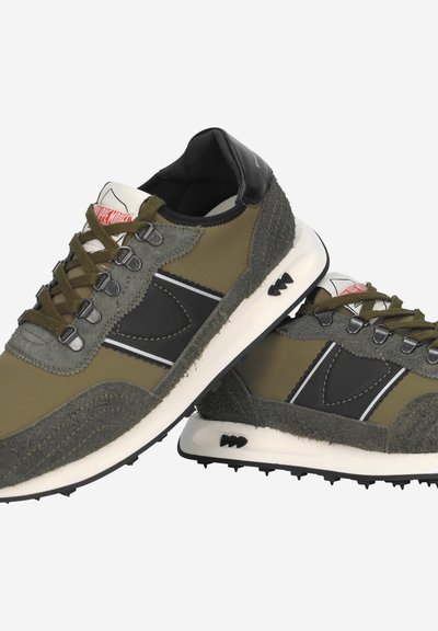 Olive green sneakers with black accents, textured suede and smooth leather materials, featuring a white outsole and metal eyelets.