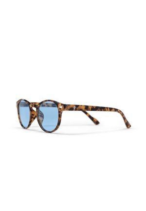 Lunettes de soleil rondes avec des verres bleus et une monture écaille de tortue marron, positionnées en angle sur un fond blanc.