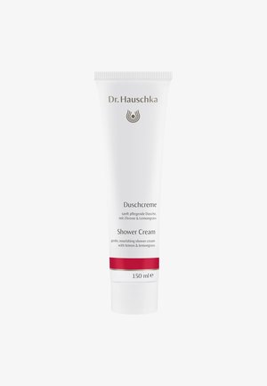 Tube souple blanche avec une bande d'accent rouge, étiquetée "Crème de Douche" avec des détails en or et noir, indiquant des ingrédients de citron et de citronnelle.