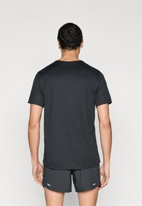 Čierne tričko s krátkym rukávom a okrúhlym výstrihom, vyrobené z hladkej látky. Zadná časť má čistý dizajn bez log alebo vzorov.