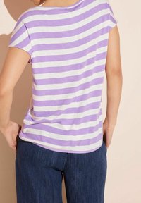 Lila och vit randig kortärmad skjorta med avspänd passform, med rundad halsringning och rak fåll, kombinerad med mörkblå byxor.