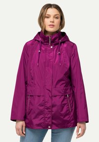 Lila vattentät jacka med huva, dragkedja fram och två sidofickor. Har justerbara dragsnören och en slät, glänsande yta.