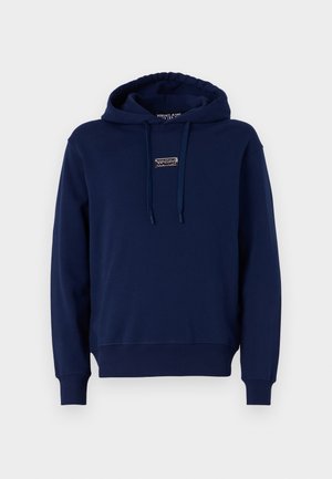 Tumesinine kapuutsiga sviiter, mis on valmistatud pehmest kangast, esiküljel on logo silti ja stringide sidumiseks. Ribitud varrukatel ja alläär korraliku istuvuse tagamiseks.