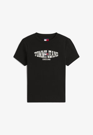 Juoda trumpomis rankovėmis suknelė su juostelėmis, ant krūtinės užrašas „TOMMY JEANS SINCE 1985“ ir mažas raudonas, baltas ir mėlynas Tommy Hilfiger vėliavos logotipas.