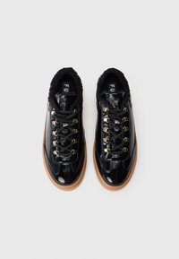 Une paire de baskets en cuir noir brillant avec des lacets noirs, des œillets dorés, une doublure en fourrure chaude et des semelles en caoutchouc brun clair, vues de dessus.