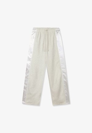 Hellgraue Sweatpants mit weißen Satin-Seitenteilen, elastischem Bund und Kordelzug, flach auf weißem Hintergrund liegend.