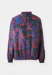 Lightweight jacket with a black base, featuring a vibrant red and blue floral pattern. It has a high collar, full zipper, and elastic cuffs.