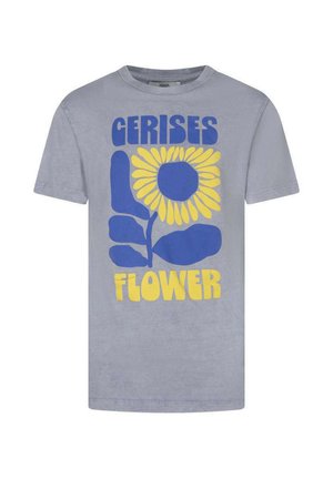 T-shirt bleu clair avec un grand tournesol stylisé bleu et jaune, avec les mots "GERISES" au-dessus et "FLOWER" en dessous du graphique.