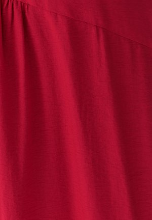 Punane kangas pehme, veidi tekstuurse pinnaga. Omab drapeeritud disaini, millel on ülaosas diagonaalne õmblus.