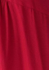 Teléfono de tela roja con una superficie suave y ligeramente texturada; presenta un brillo sutil y una caída suave, ideal para la confección de ropa.