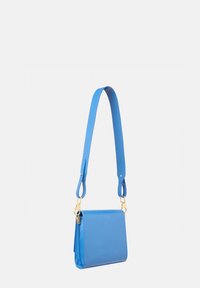 Borsa a tracolla blu in pelle, forma quadrata, con una superficie liscia, tracolla regolabile e accessori in metallo dorato. Nome del modello impresso.