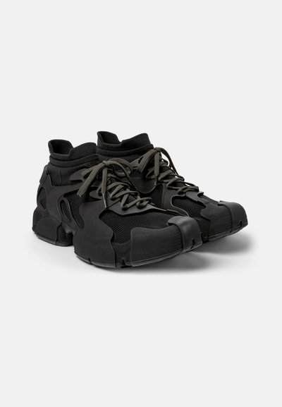 Sorte højtop sneakers med en overdel i tekstil og gummi, der har et unik lagdelt design og tykke snørebånd. Rund tå og polstret krave.