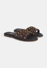 Bruine slide sandalen met meerdere overlappende banden versierd met gouden studs, met een zwarte comfortabele binnenzool en een bruine buitenzool.