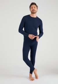 Navy blue long-sleeve top and fitted bottom, made of soft fabric. Minimalist design with ribbed cuffs and a crew neckline.