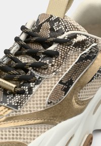 Sneakers met een slangenprintontwerp, beige en gouden accenten, mesh materiaal, zwarte veters en een textuurrijke, gedempte zool.