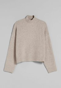 Beige gebreide coltrui met een cropped ontwerp, geribbelde zoom en losvallende mouwen, met een zachte, textuurgevende afwerking.