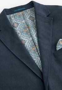 Marineblazer aus texturiertem Stoff, mit gefüttert in hellblauem Muster mit floralen und geometrischen Designs und einer passenden Taschentasche.