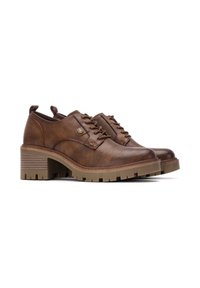 Zapatos de cuero marrón con puntera redondeada, diseño con cordones y tacón texturizado en marrón. Acento metálico notable en el lateral. Suela de goma gruesa.