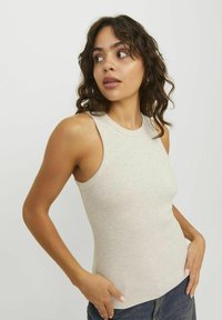 Lys beige ribbet tanktop med tætsiddende silhuet, rund hals og ærmeløs design, lavet af et blødt, tekstureret stof.