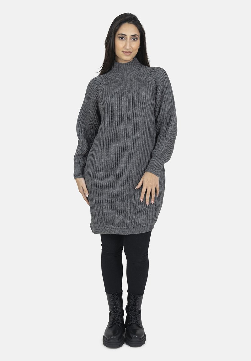 Chunky strikket grå sweaterkjole med høj hals, ribbet tekstur og lange ærmer. Kombinationen med sorte leggings og kampstøvler.