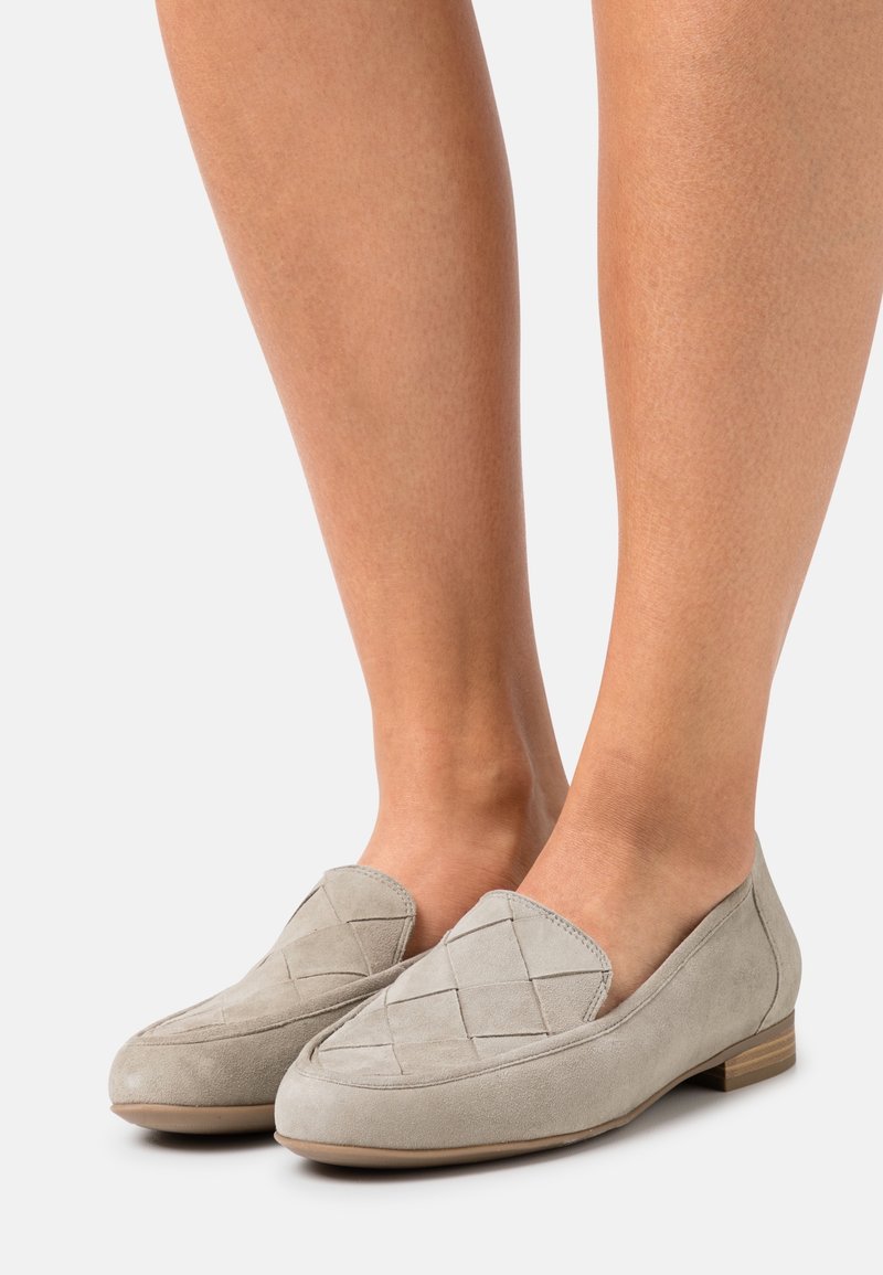 Mocassins en daim gris avec un design matelassé sur la partie supérieure, un petit talon en bois et un bout arrondi. Conviennent pour un usage décontracté.