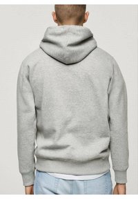 Grijze hoodie van zacht materiaal, voorzien van een grote capuchon, geribde manchetten en een ontspannen pasvorm. De achterkant toont een gladde textuur en naden.