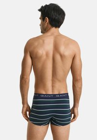 Heren boxershorts in marineblauw met groene en witte horizontale strepen. Zacht katoenen materiaal, elastische tailleband met herhaald merklogo.