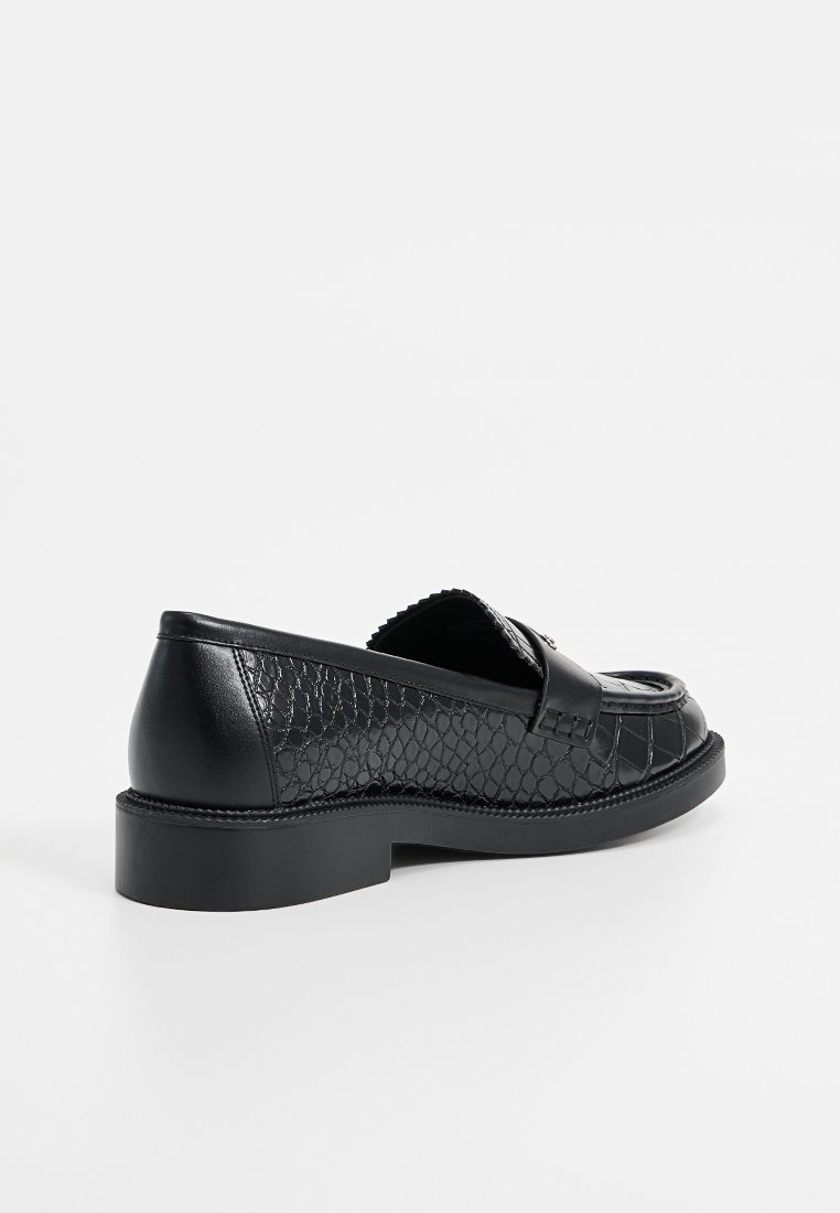 Schwarze Lederloafers mit einem strukturierten Schlangenledermuster, runder Zehe, niedrigem Absatz und einem dekorativen Riemen über dem Vorderfuß.