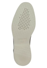 Semelle de chaussure Geox, en caoutchouc blanc avec un motif quadrillé texturé et des perforations pour la respirabilité. Présente le logo "Geox Brevet Italien."