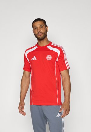Red athletic shirt made of smooth fabric, featuring white accents and the FC Bayern Munich logo on the left chest. Black stripes on shoulders.
