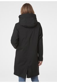 Černá parka s kapucí, která má rovný střih, dlouhé rukávy a rozparek na zadní straně pro snadný pohyb. Vyrobena z hladké tkaniny.