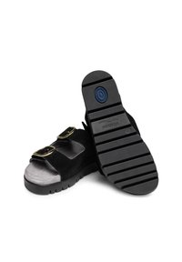 Black suede sandals with dual buckles, soft gray insole, and textured rubber soles featuring a patterned grip for stability.